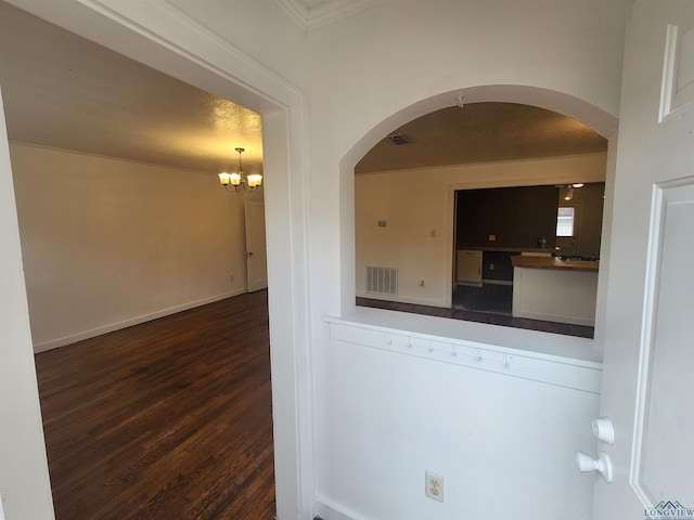 empty room featuring dark hardwood / wood-style flooring and an inviting chandelier