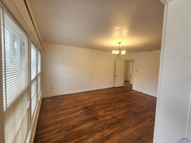 unfurnished room featuring a textured ceiling, an inviting chandelier, and dark wood-type flooring