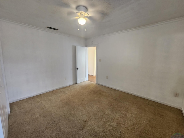 spare room featuring crown molding, ceiling fan, and light carpet