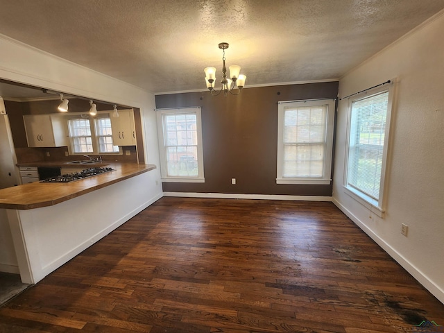 kitchen featuring pendant lighting, dark hardwood / wood-style flooring, kitchen peninsula, and an inviting chandelier