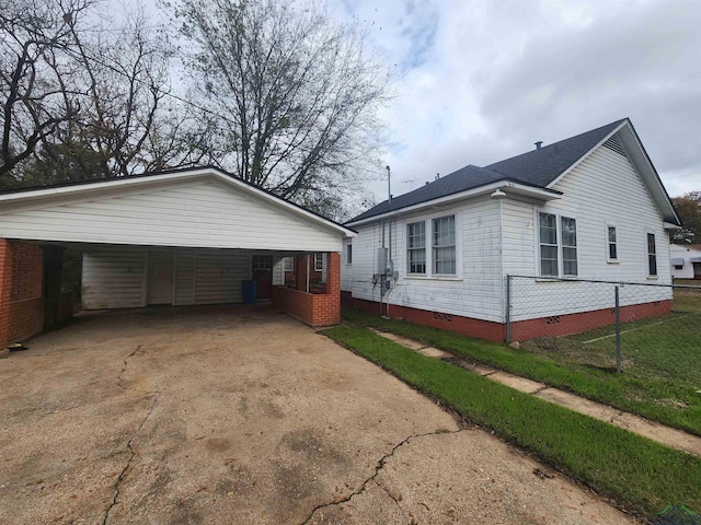 view of property exterior featuring a lawn and a carport