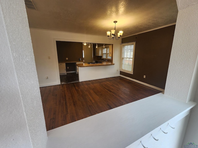 interior space with wooden counters, kitchen peninsula, dark hardwood / wood-style flooring, a textured ceiling, and a notable chandelier