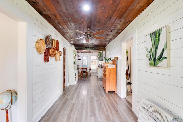 hall with wood walls, hardwood / wood-style floors, and wood ceiling