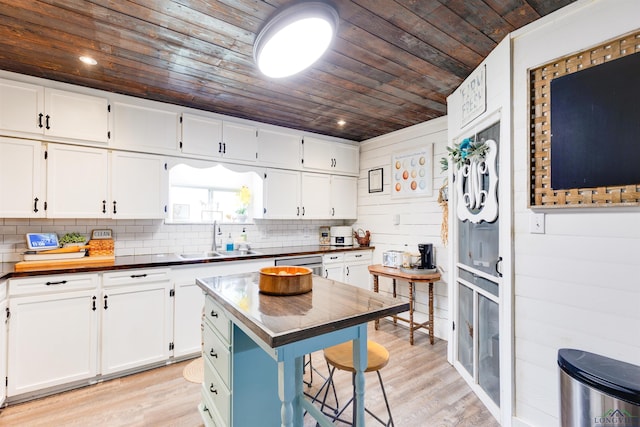 kitchen featuring a center island, wooden ceiling, white cabinets, sink, and light wood-type flooring