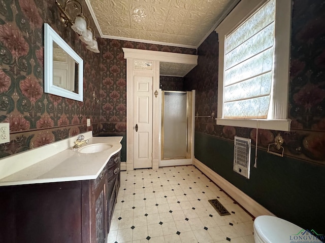 bathroom with vanity, toilet, a shower with door, and heating unit