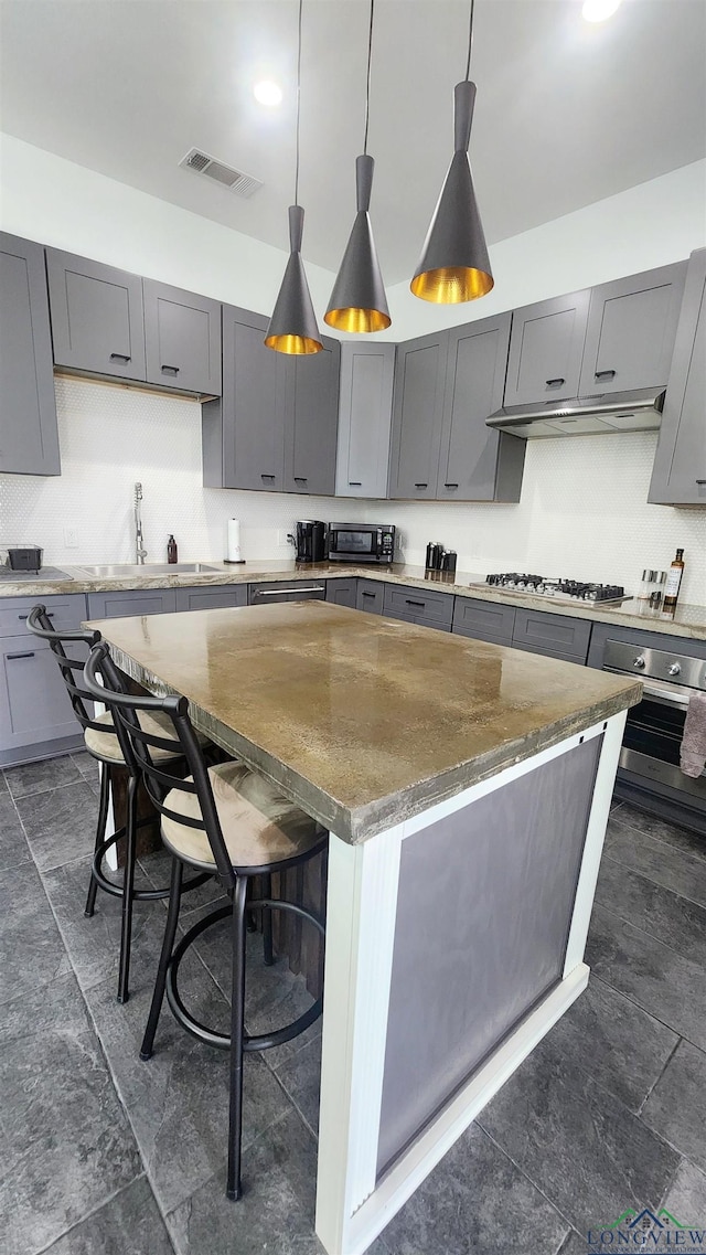 kitchen featuring a kitchen breakfast bar, gray cabinetry, and a kitchen island