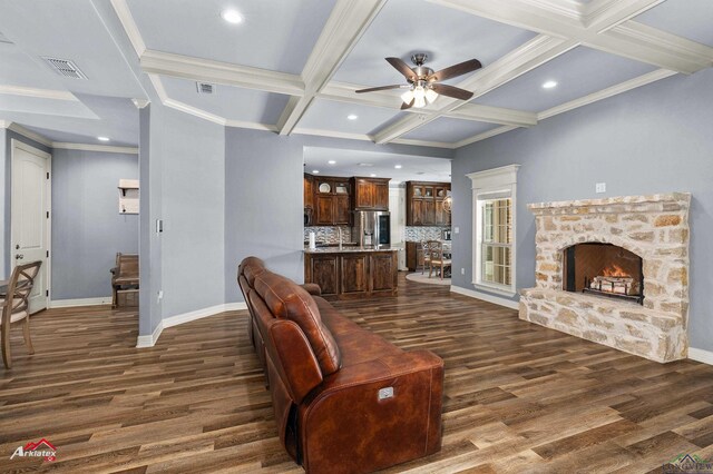 224 Stonegate Dr, Carthage, TX 75633 - living area featuring dark wood-style flooring, a ceiling fan, coffered ceiling, beamed ceiling, and a stone fireplace
