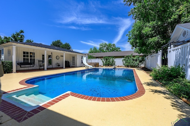 view of pool with a diving board, a patio area, and a water slide