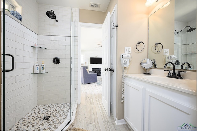 bathroom with wood-type flooring, vanity, and a shower with door