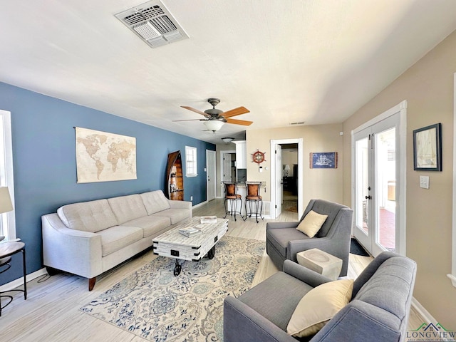 living room featuring light hardwood / wood-style flooring and ceiling fan