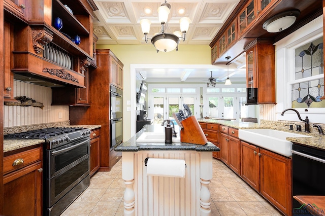 kitchen featuring black appliances, light stone counters, sink, and french doors