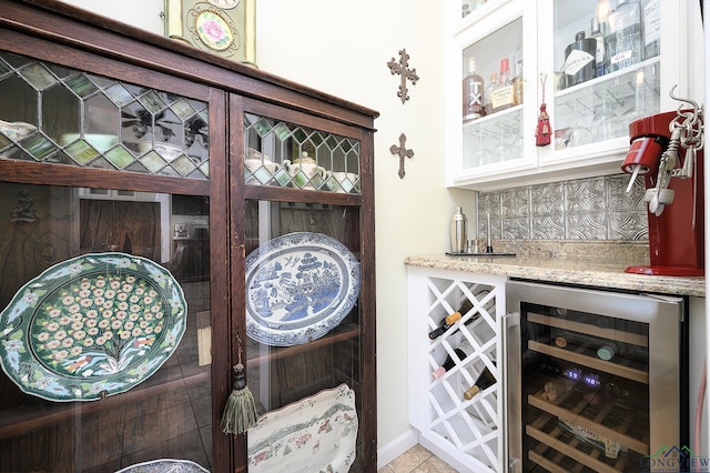 interior space with decorative backsplash, light tile patterned floors, wine cooler, and light stone countertops