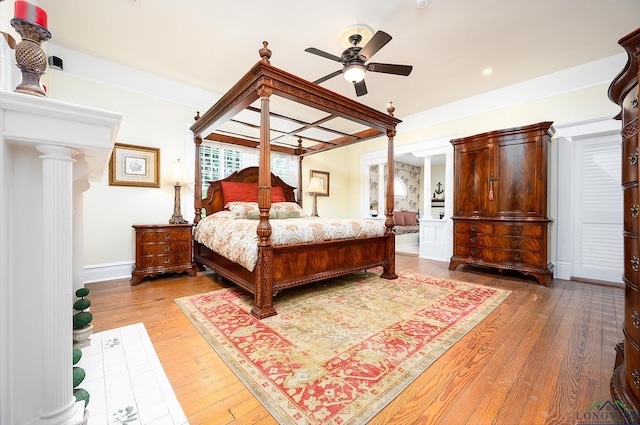 bedroom featuring ornate columns, ceiling fan, and wood-type flooring