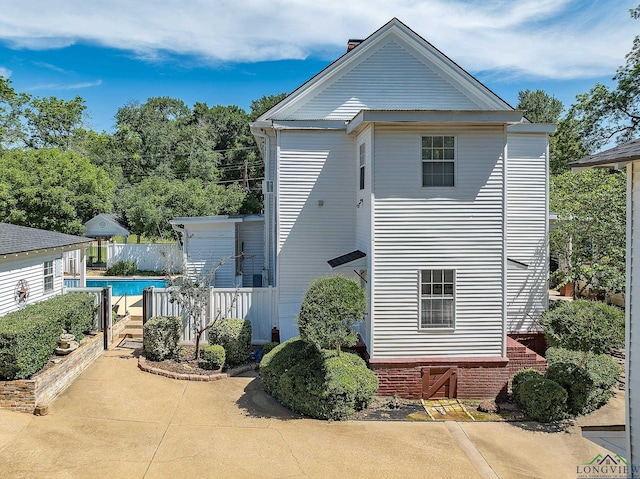 view of property exterior featuring a fenced in pool