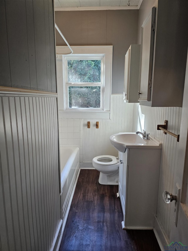 full bathroom with vanity, wood walls, bathing tub / shower combination, hardwood / wood-style flooring, and toilet