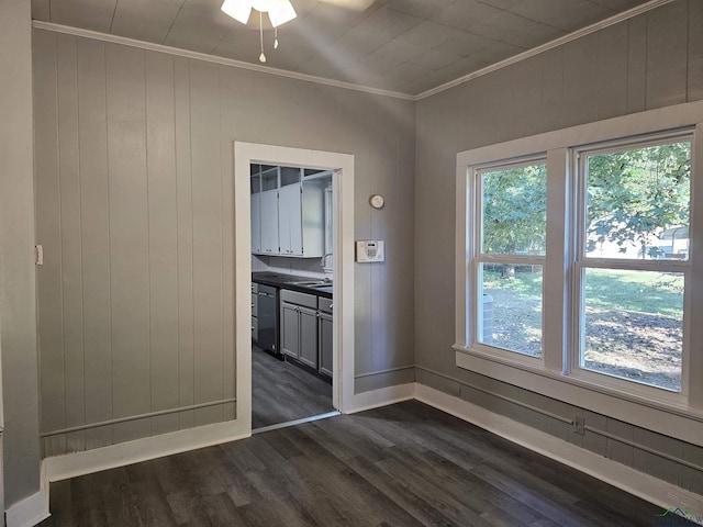 unfurnished dining area with crown molding, wooden walls, and dark hardwood / wood-style floors