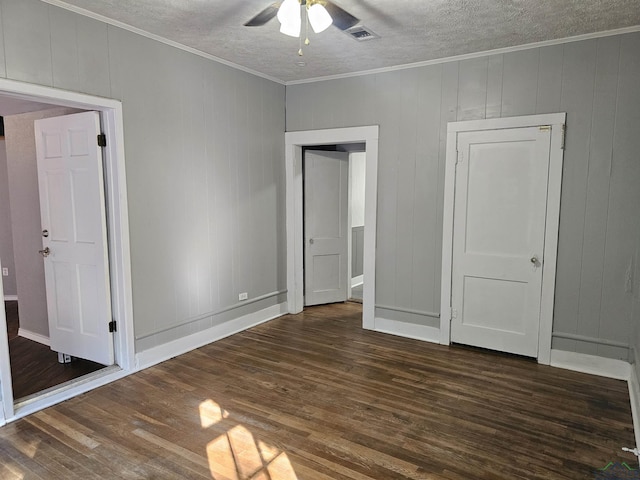 unfurnished bedroom featuring ceiling fan, crown molding, and dark wood-type flooring