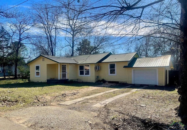 single story home featuring a garage and an AC wall unit