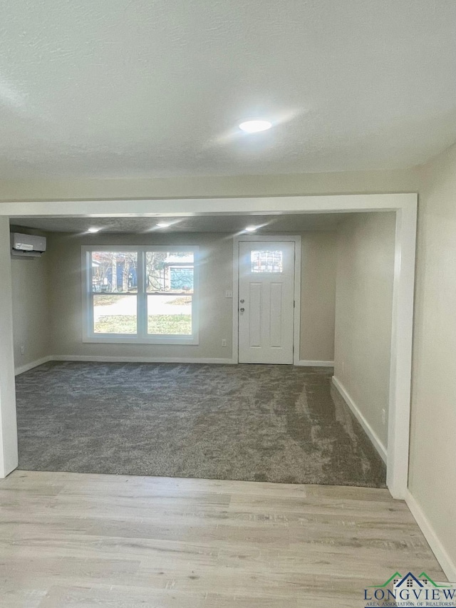 carpeted foyer featuring a wall mounted air conditioner