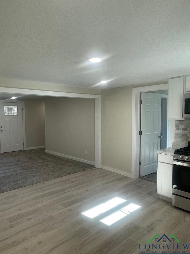 interior space with a textured ceiling and light wood-type flooring