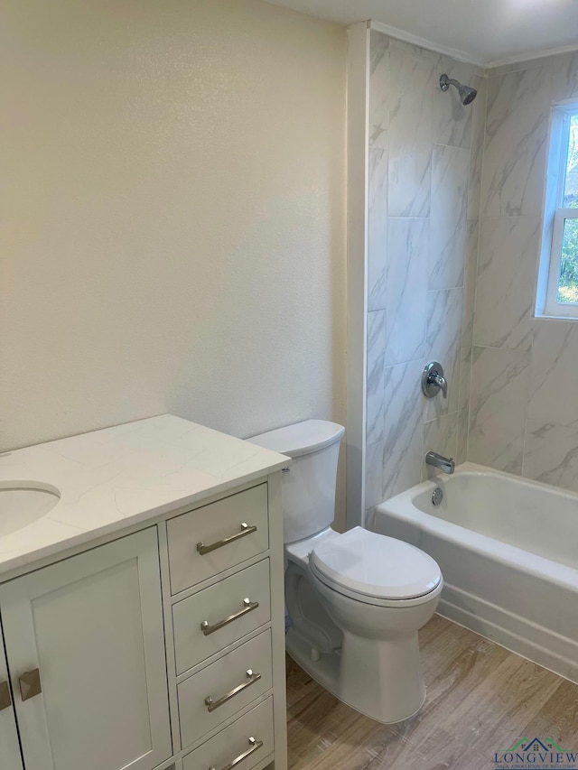 full bathroom with vanity, hardwood / wood-style floors, toilet, and tiled shower / bath