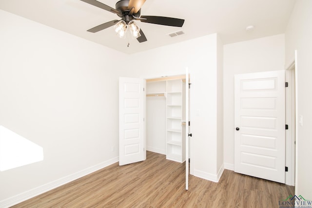 unfurnished bedroom with ceiling fan, light hardwood / wood-style flooring, and a closet