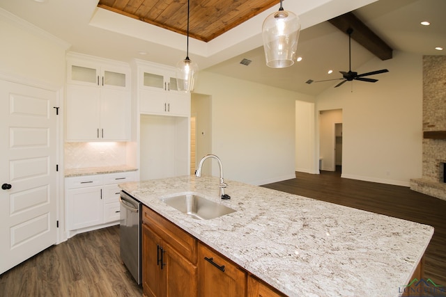 kitchen featuring white cabinets, light stone counters, a center island with sink, and sink