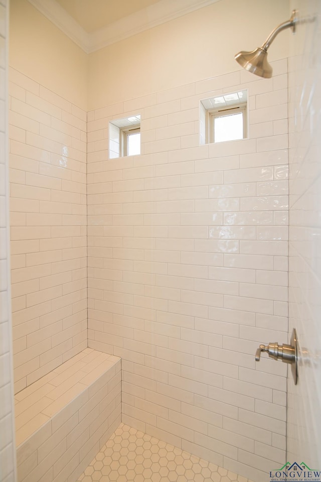 bathroom featuring tiled shower and crown molding