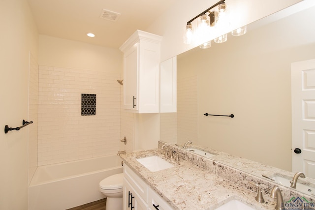 full bathroom with vanity, tiled shower / bath, and toilet