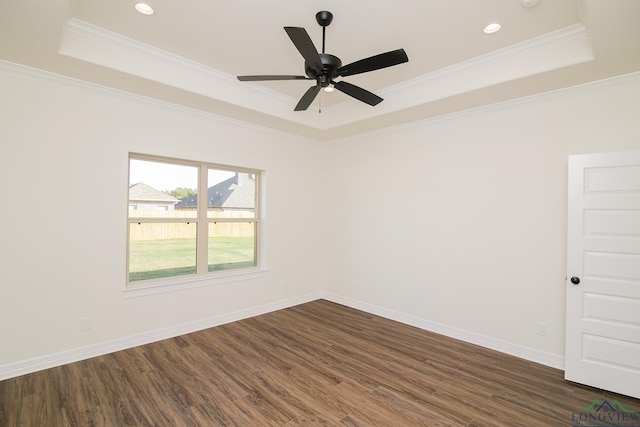 unfurnished room featuring a tray ceiling, dark hardwood / wood-style floors, crown molding, and ceiling fan