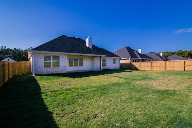 rear view of property featuring a yard