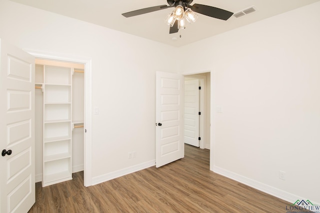 unfurnished bedroom with ceiling fan, a closet, and dark hardwood / wood-style floors