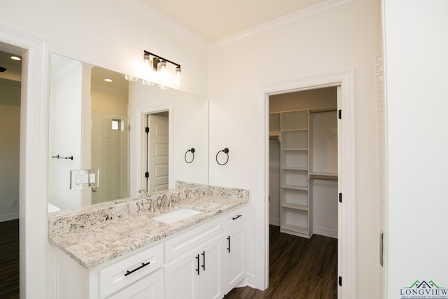 bathroom featuring vanity, wood-type flooring, ornamental molding, and walk in shower