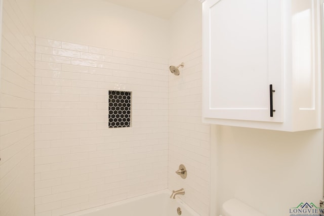 bathroom with tiled shower / bath combo and toilet