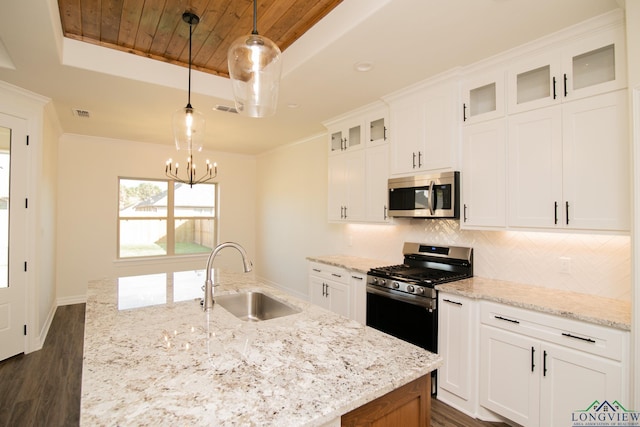 kitchen featuring pendant lighting, white cabinets, sink, a notable chandelier, and stainless steel appliances