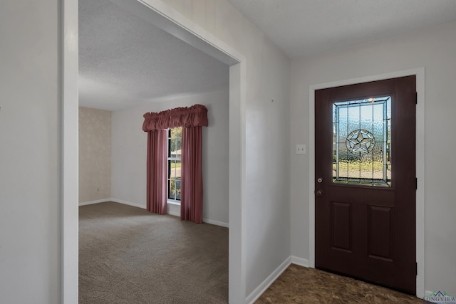 foyer featuring dark colored carpet and a textured ceiling