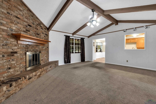 unfurnished living room featuring ceiling fan, a brick fireplace, vaulted ceiling with beams, a textured ceiling, and carpet