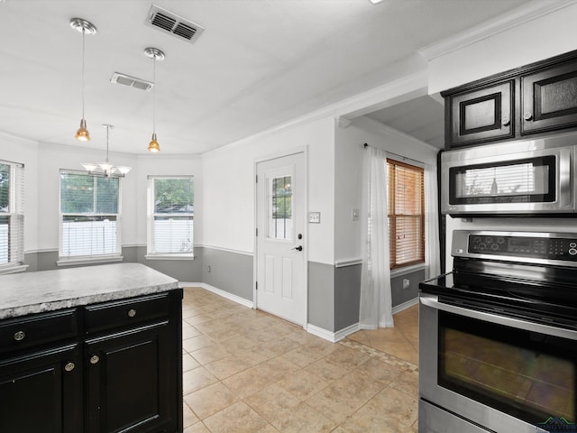 kitchen featuring stainless steel appliances, dark cabinetry, light countertops, baseboards, and hanging light fixtures