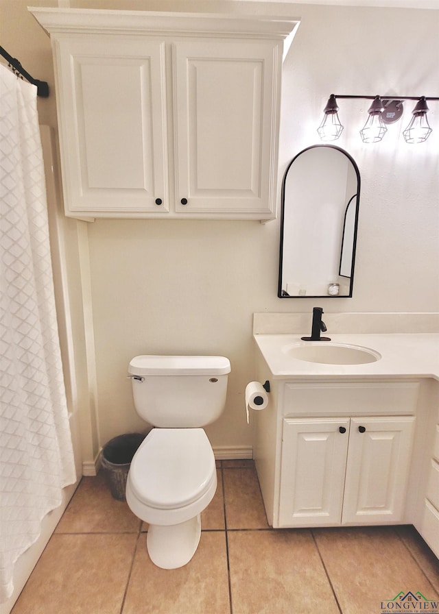 bathroom with tile patterned flooring, vanity, and toilet