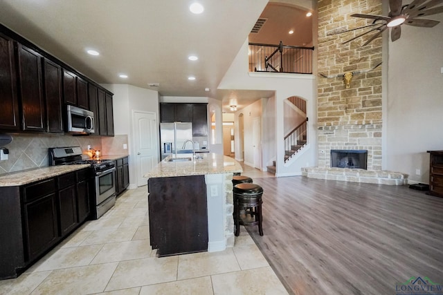 1126 Ruddy Duck, New Braunfels, TX 78130 - kitchen with stainless steel appliances, a sink, light stone countertops, a high ceiling, and arched walkways