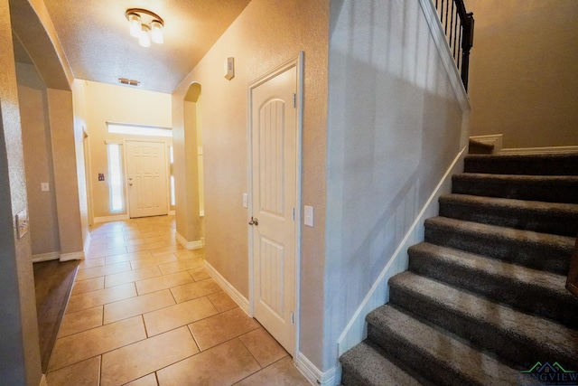 1126 Ruddy Duck, New Braunfels, TX 78130 - stairs with tile patterned flooring, arched walkways, and baseboards