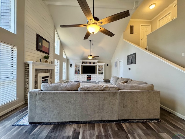 living room featuring ceiling fan, a brick fireplace, crown molding, dark wood-type flooring, and high vaulted ceiling