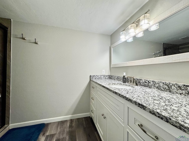 bathroom with hardwood / wood-style flooring, a shower, and vanity