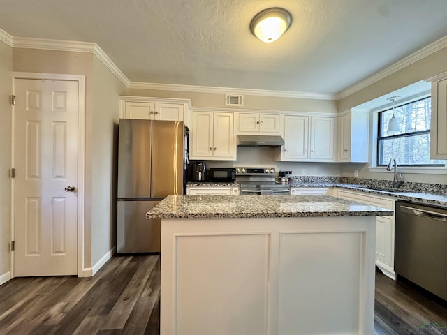 kitchen with white cabinets, appliances with stainless steel finishes, and a kitchen island