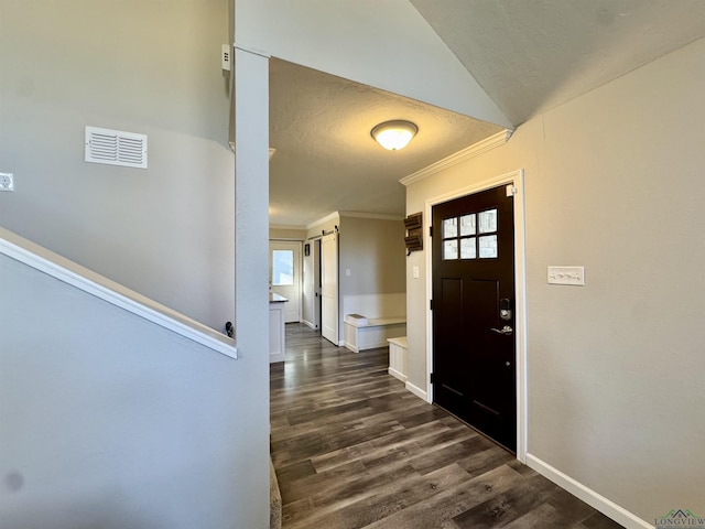 foyer with lofted ceiling, dark hardwood / wood-style flooring, and crown molding