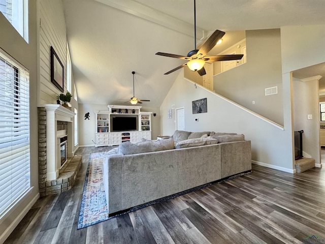 living room featuring high vaulted ceiling, a fireplace, and plenty of natural light