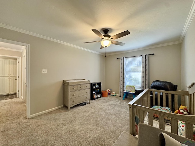 bedroom with ceiling fan, ornamental molding, light carpet, and a crib