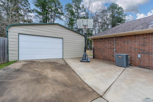 detached garage featuring fence and central AC unit