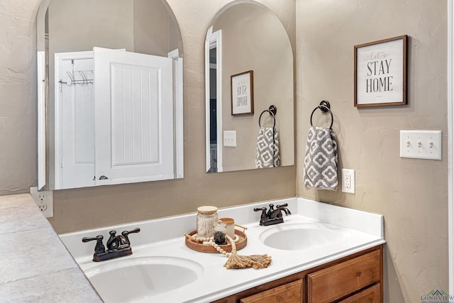 bathroom featuring a sink and double vanity