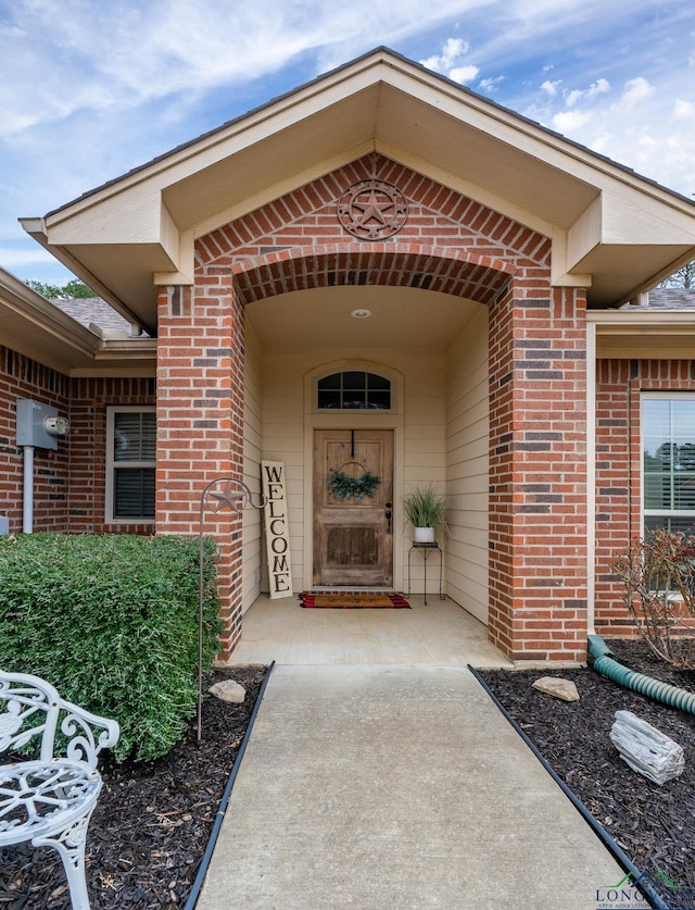 doorway to property with brick siding